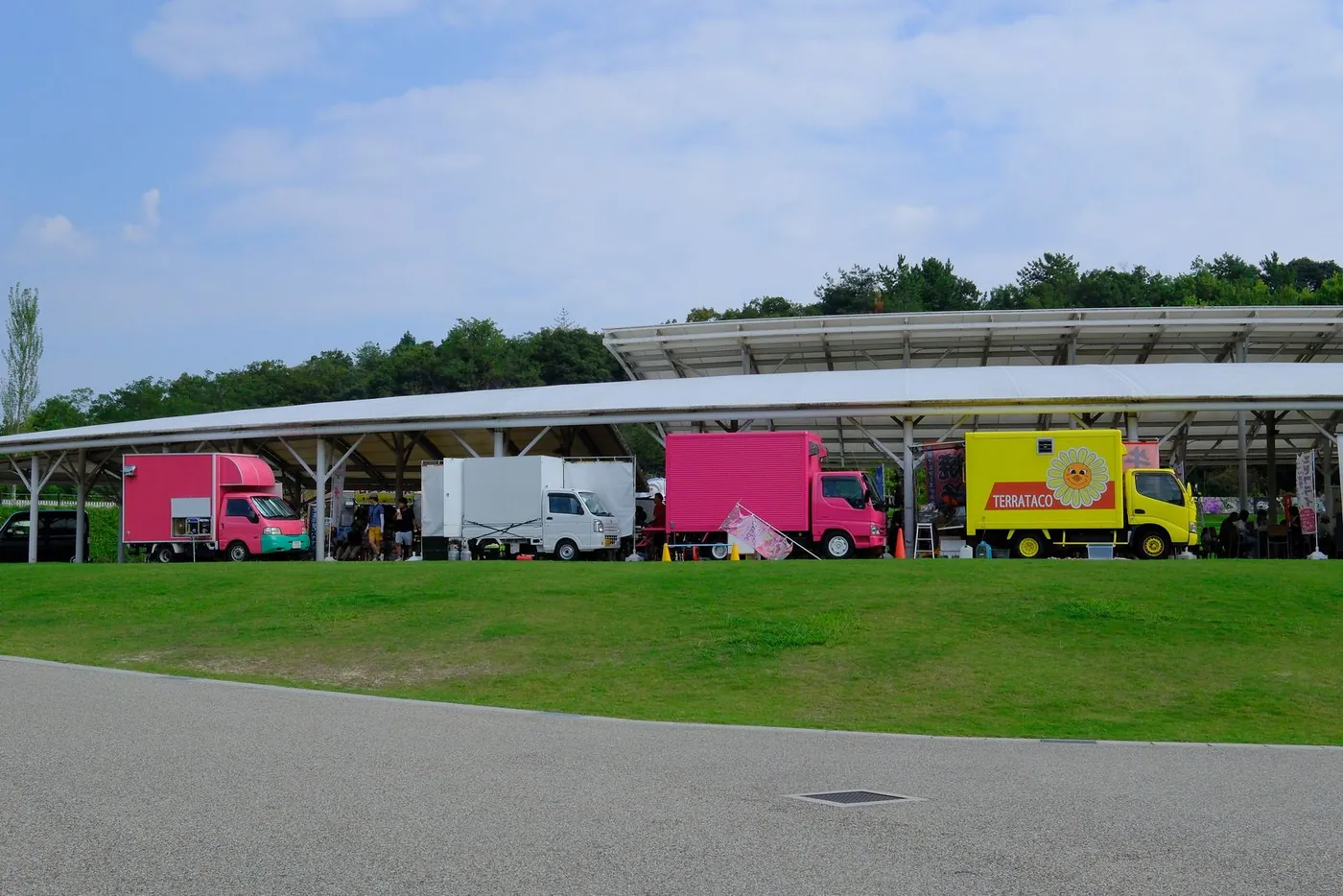 公園の芝生に並ぶ出店とキッチンカー