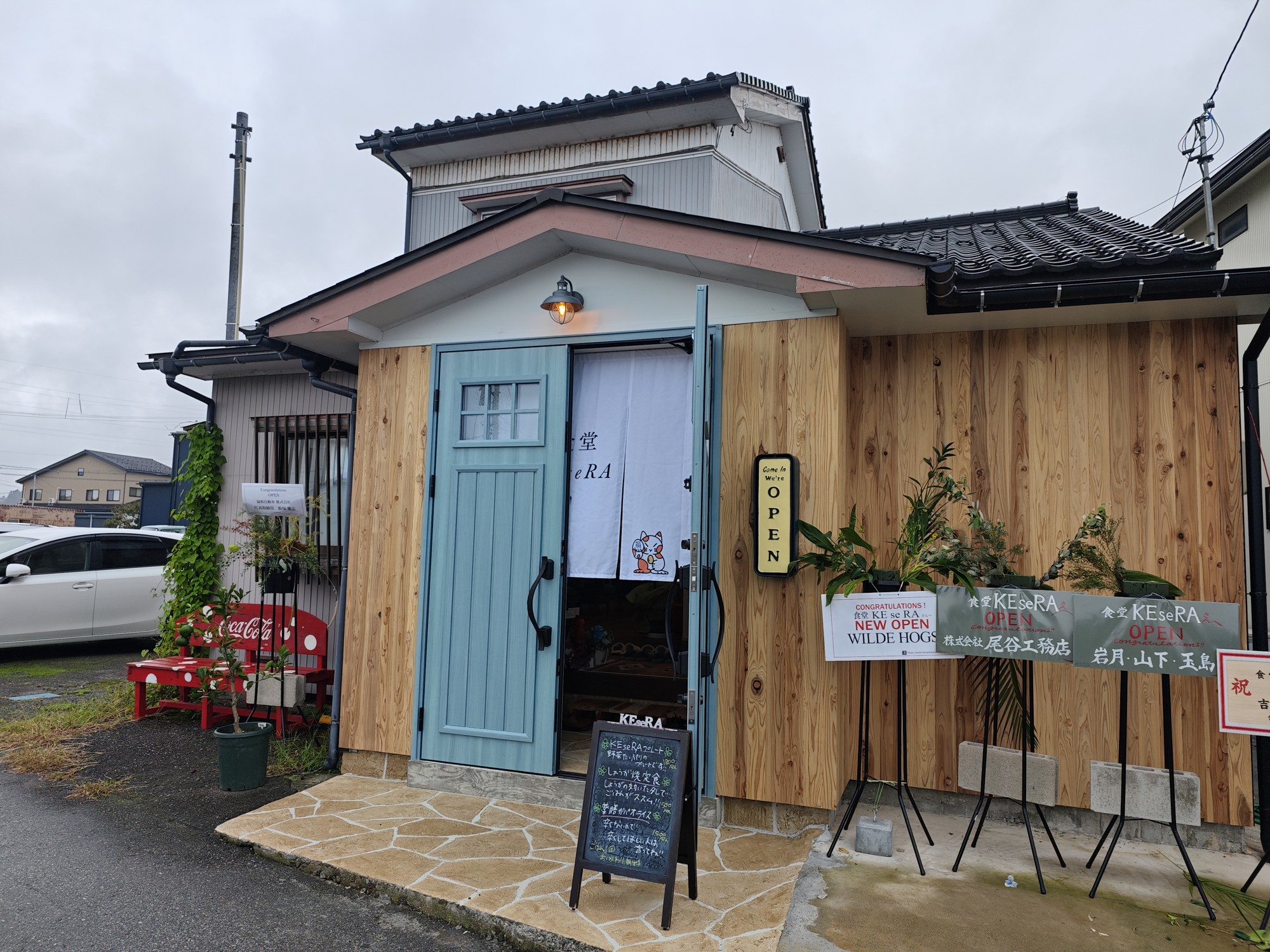 食堂KEseRAの木の外壁と水色の入口