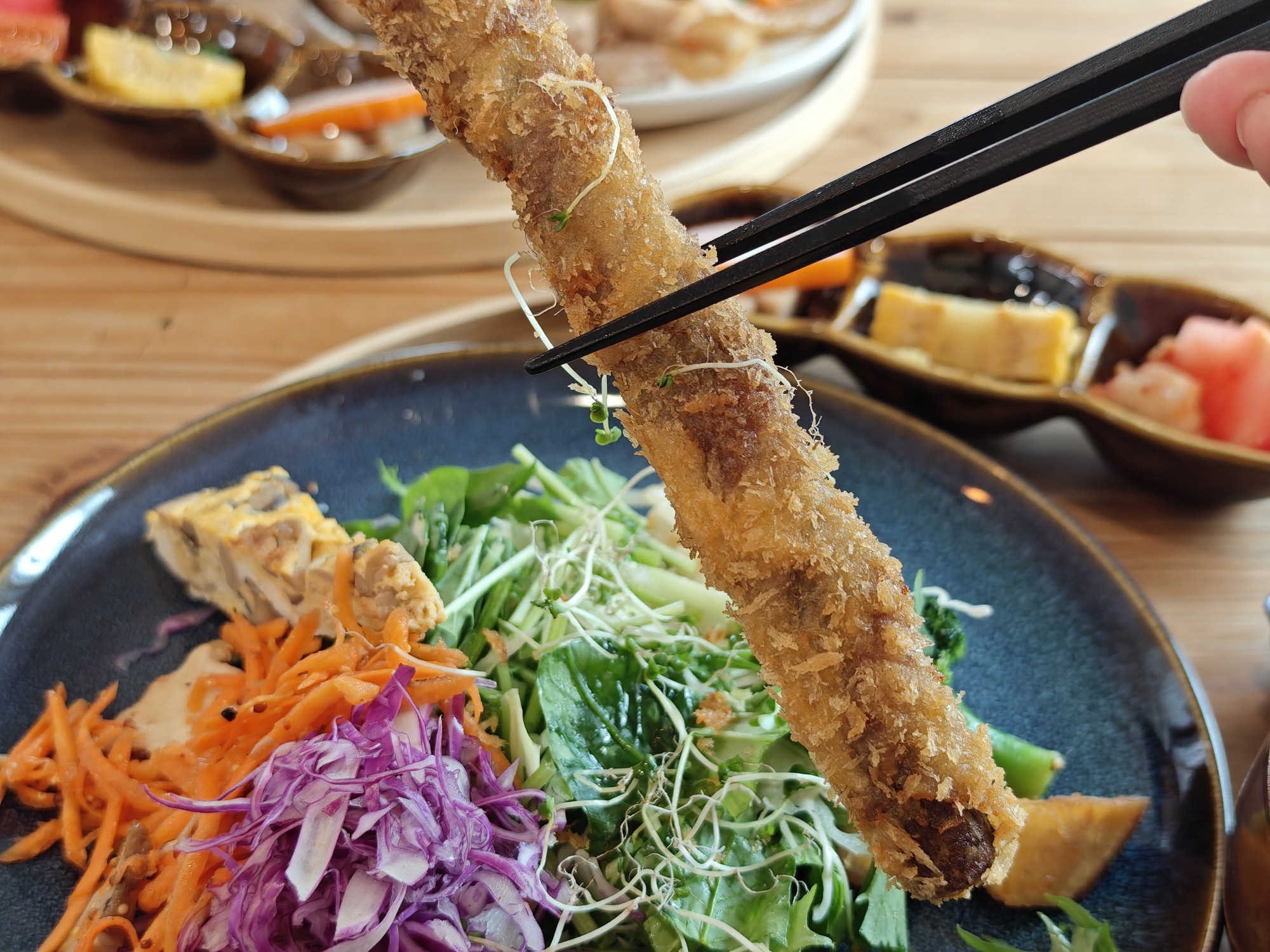 箸で持ち上げた長いごぼうの肉巻き