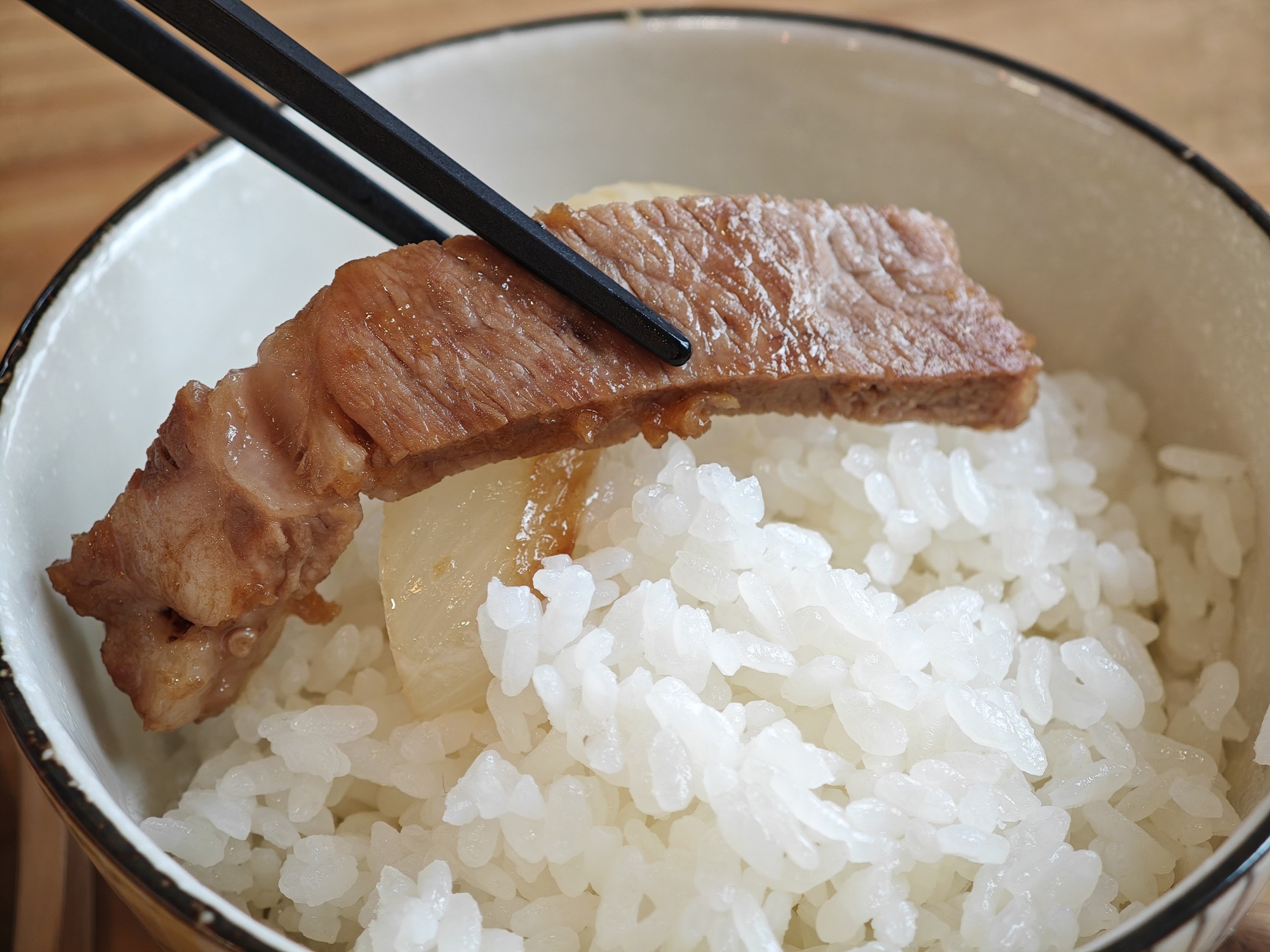 箸で持ち上げた厚みのある豚ロース